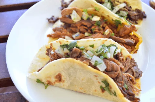 Barbacoa tacos with onion and cilantro